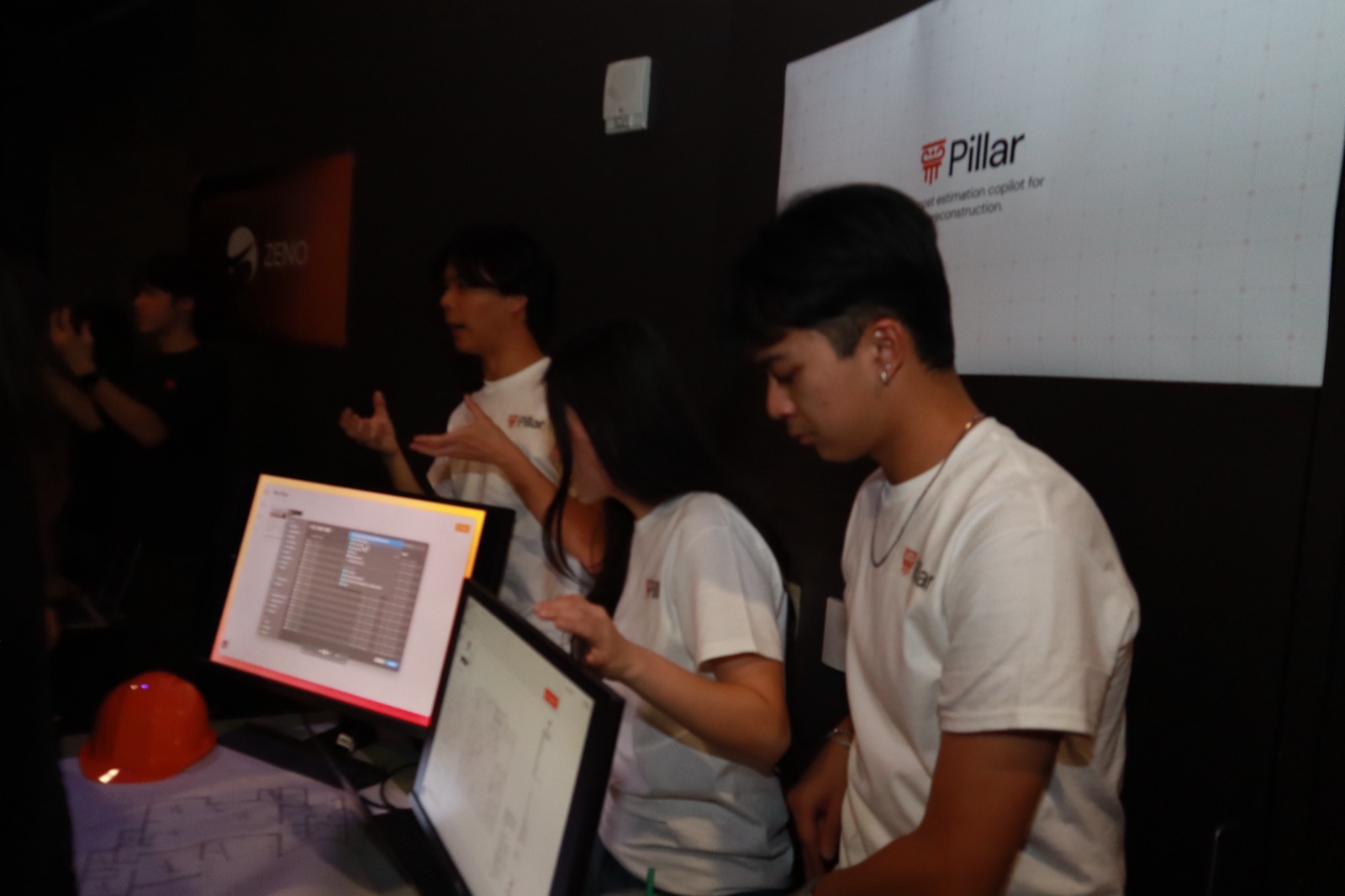 The Pillar team demoing the product on monitors at their Demo Night booth.